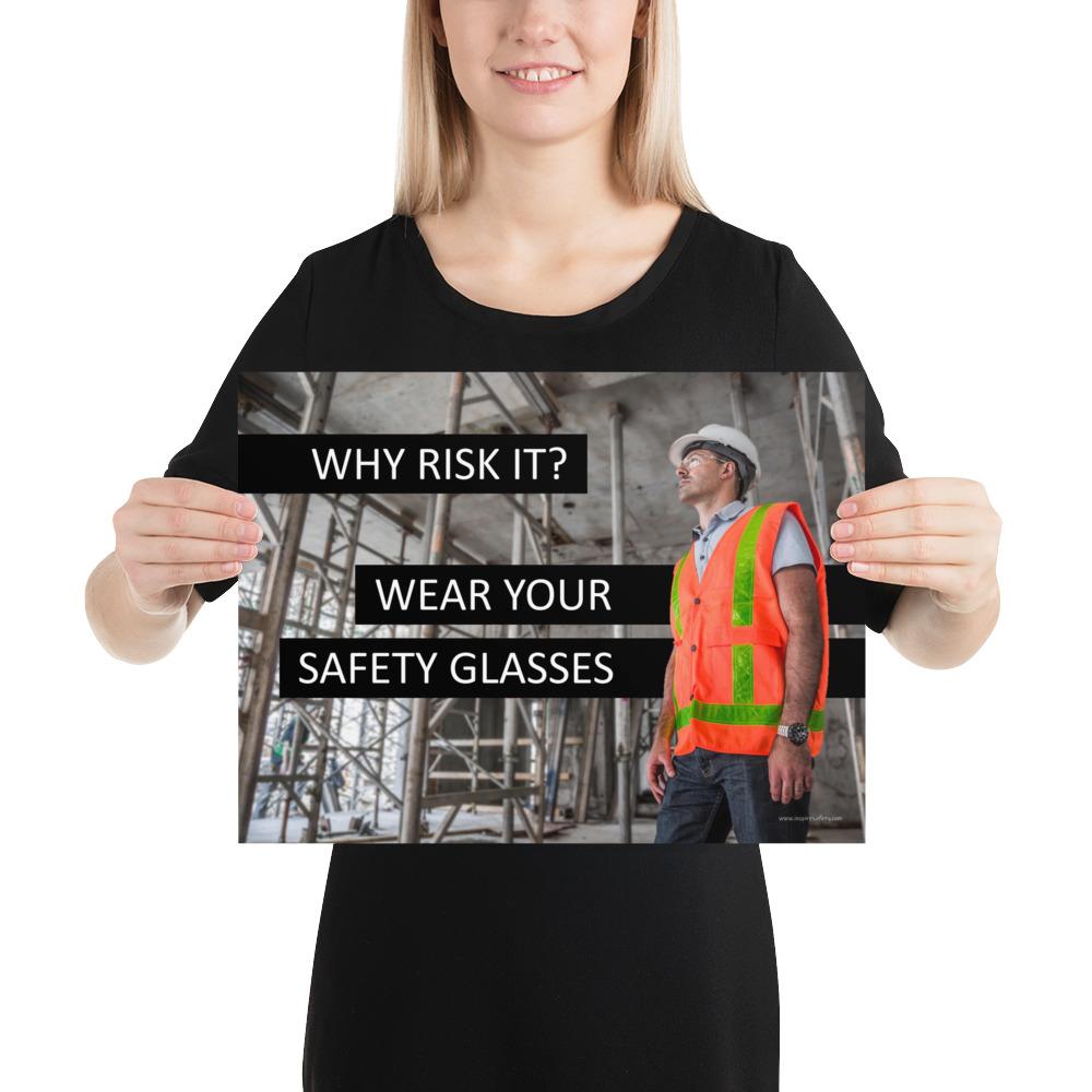 A safety poster showing a construction worker in a reflective orange vest, hard hat, and safety glasses on a construction site looking out with a safety slogan to the left.