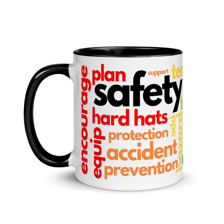 White ceramic mug with safety terms like hard hats, protection, and encourage, in a rainbow pattern across the mug with a black rim, inside, and handle.