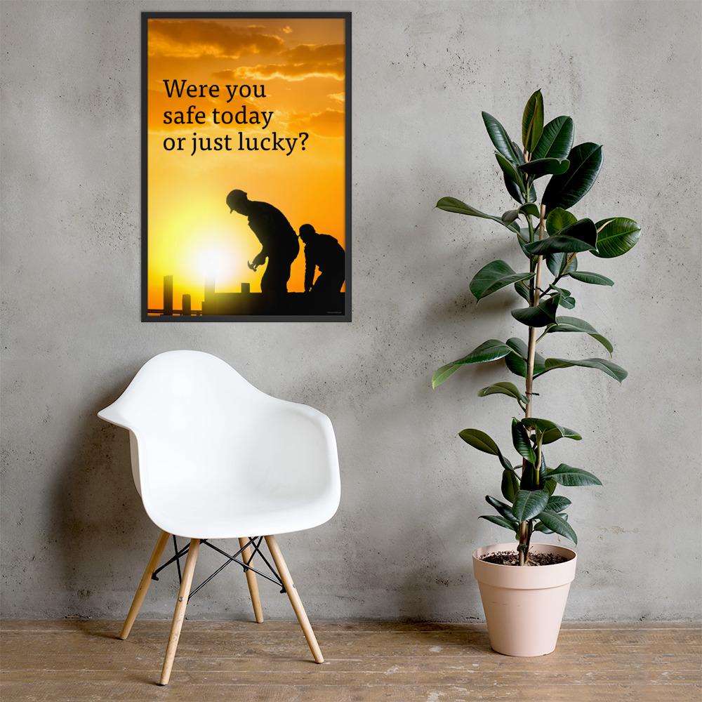 A workplace safety poster showing workers on a construction site being silhouetted in black with a sunset of orange hues in the background with the slogan were you safe today, or just lucky?