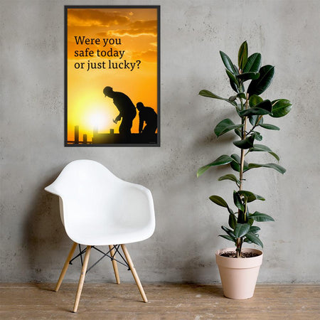 A workplace safety poster showing workers on a construction site being silhouetted in black with a sunset of orange hues in the background with the slogan were you safe today, or just lucky?