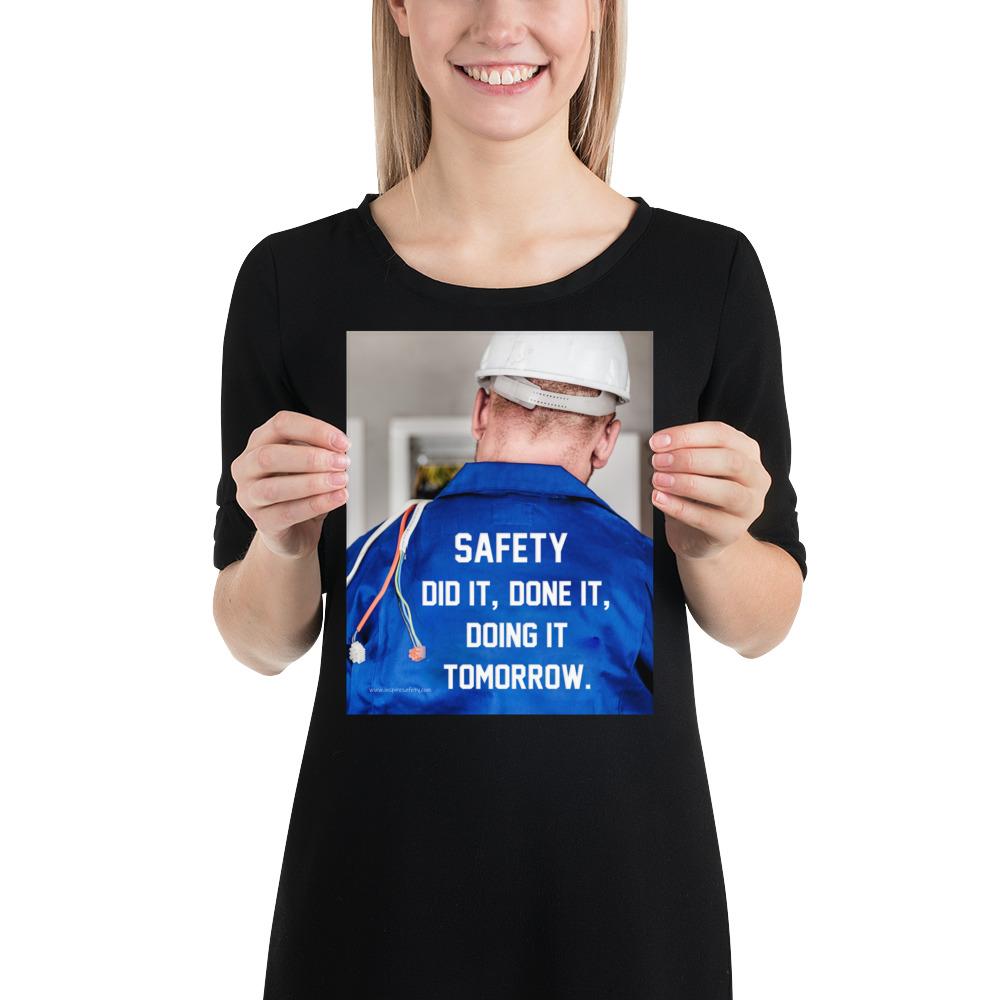 Safety poster showing an electrician wearing a hard hat and holding cables working on an electrical panel with text on the back of his bright blue shirt.