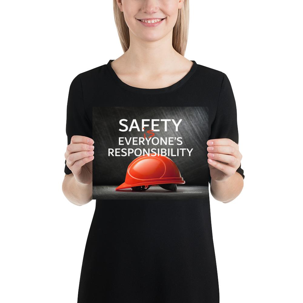 A workplace safety poster showing a red hard hat in front of a grey, industrial-looking background with the slogan safety is everyone's responsibility.