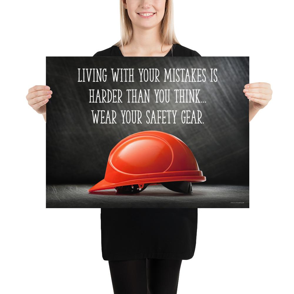 A workplace safety poster showing a bright red hard hat with an ominous black background with the slogan living with your mistakes is harder than you think, wear your safety gear.