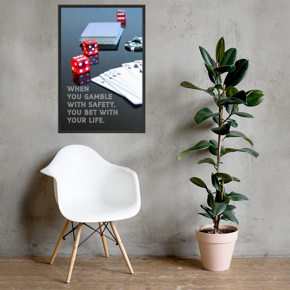 A workplace safety poster of a glossy black table with red dice, playing cards, and poker chips strewn everywhere with a safety slogan in the bottom left corner.
