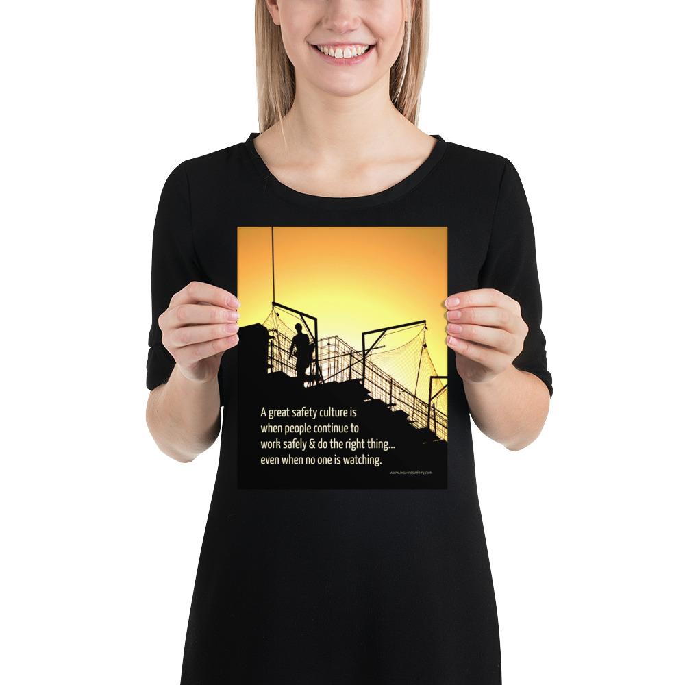 A construction safety poster showing the silhouette of a construction worker working on a building with a bright yellow sunset in the background and a safety slogan in the bottom left corner.
