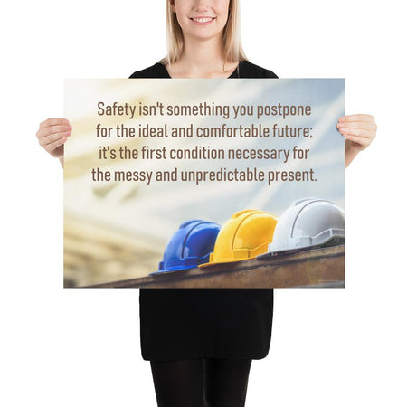 A workplace safety poster showing 3 multi colored hardhats sitting on a wall with the slogan safety isn't something you postpone for the ideal and comfortable future. It's the first condition necessary for the messy and unpredictable present.