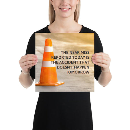 A workplace safety poster showing an orange safety cone with the slogan the near miss reported today is the accident that doesn't happen tomorrow.
