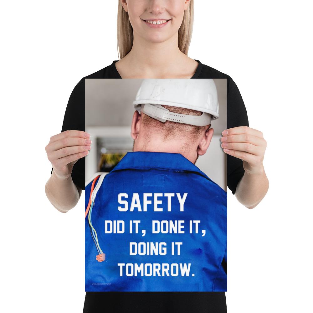 Safety poster showing an electrician wearing a hard hat and holding cables working on an electrical panel with text on the back of his bright blue shirt.