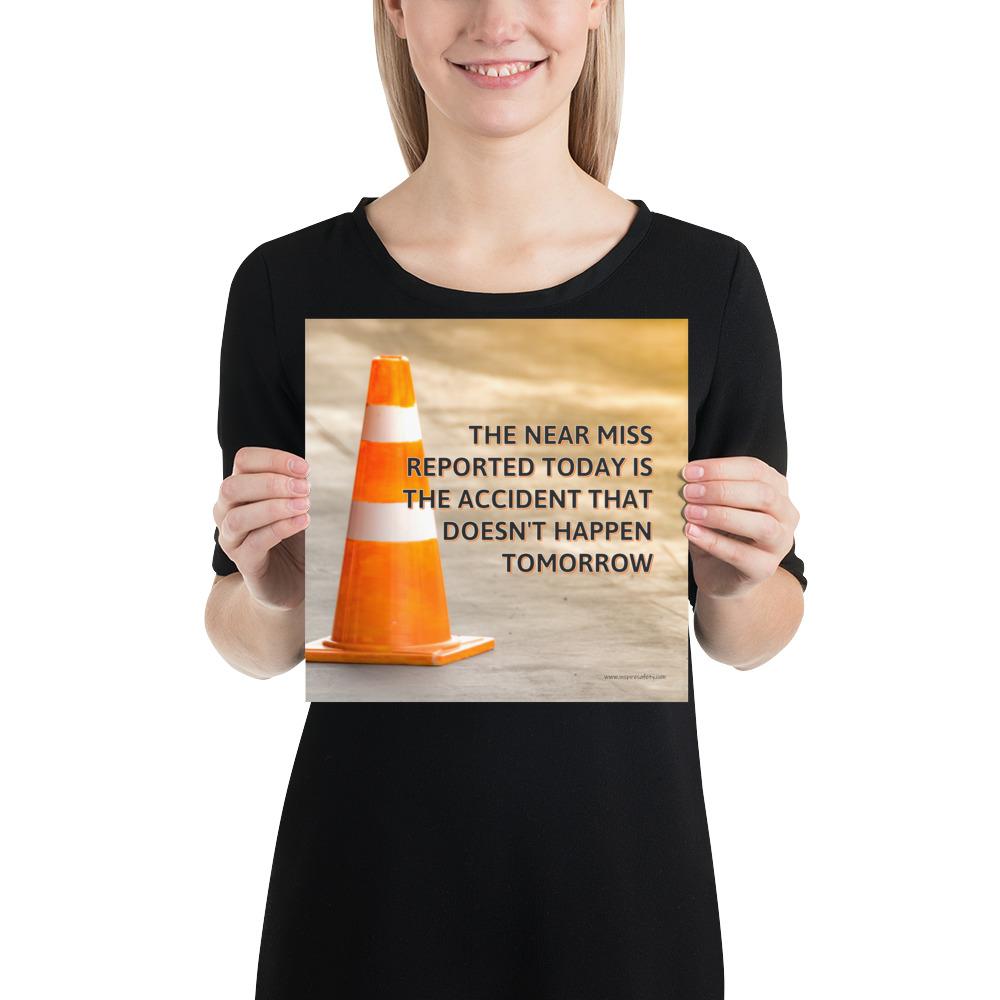 A workplace safety poster showing an orange safety cone with the slogan the near miss reported today is the accident that doesn't happen tomorrow.