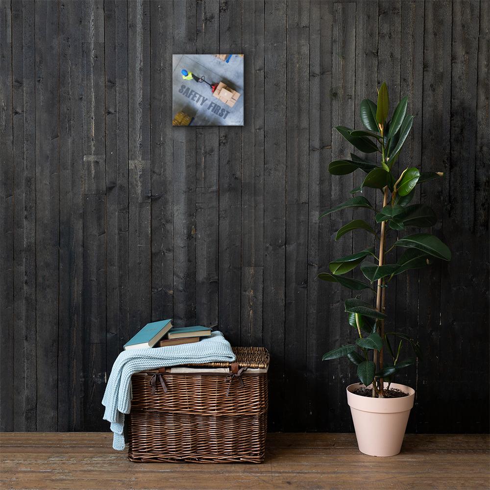 A safety poster showing a bird's-eye view of a worker in a warehouse pulling boxes on a pallet jack with the slogan safety first in bold letters.