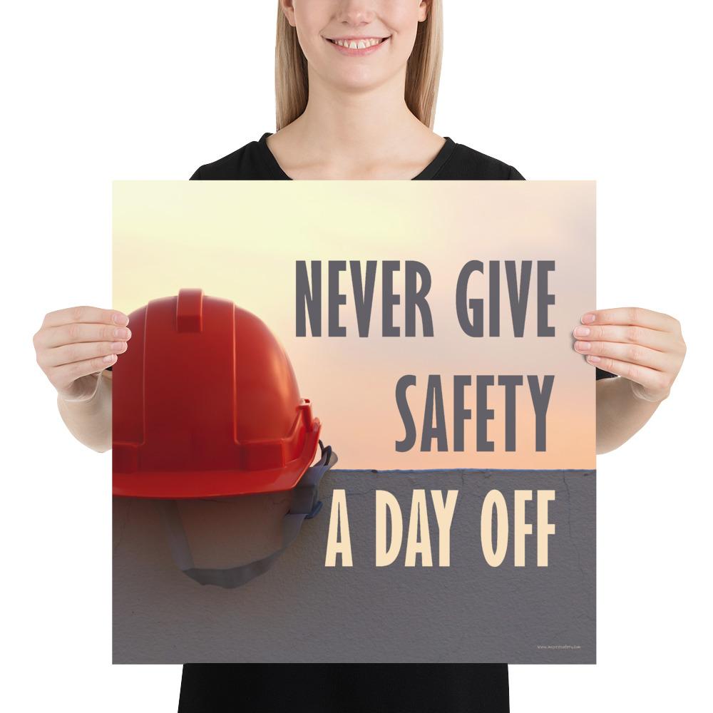 A workplace safety poster depicting a red hard hat sitting on a concrete wall with a dreamy pink sunset in the background with the text never give safety a day off to the right.