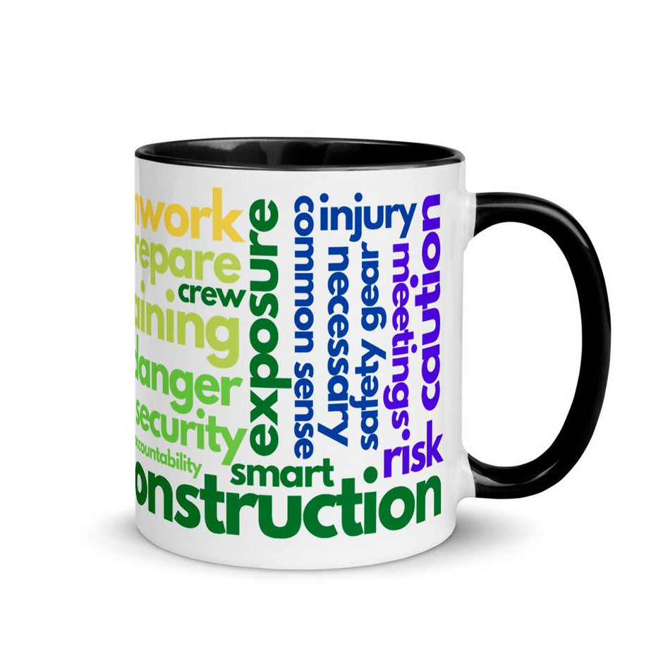 White ceramic mug with safety terms like hard hats, protection, and encourage, in a rainbow pattern across the mug with a black rim, inside, and handle.