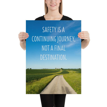 A workplace safety poster depicting a beautiful sunny day with a bright blue sky and a lush green field being cut down the middle by a dirt road leading off into the countryside with the text safety is a continuing journey, not a final destination.