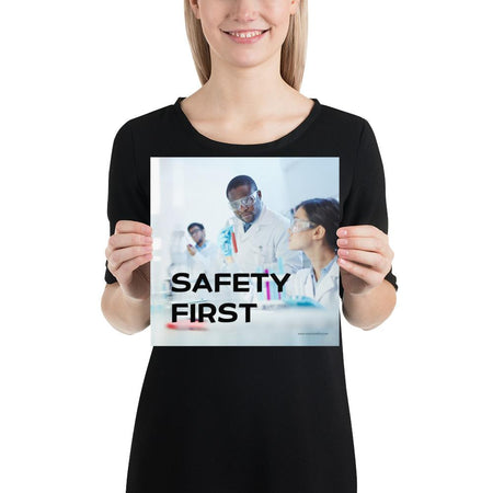 A safety poster showing two lab workers collaborating on a project in a lab while wearing full PPE with the slogan safety first.