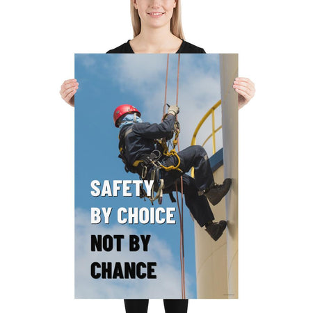 A fully harnessed man wearing a hard hat scaling the side of a building with a bright blue sky and clouds in the background with the text safety by choice, not by chance in bold text to his left.