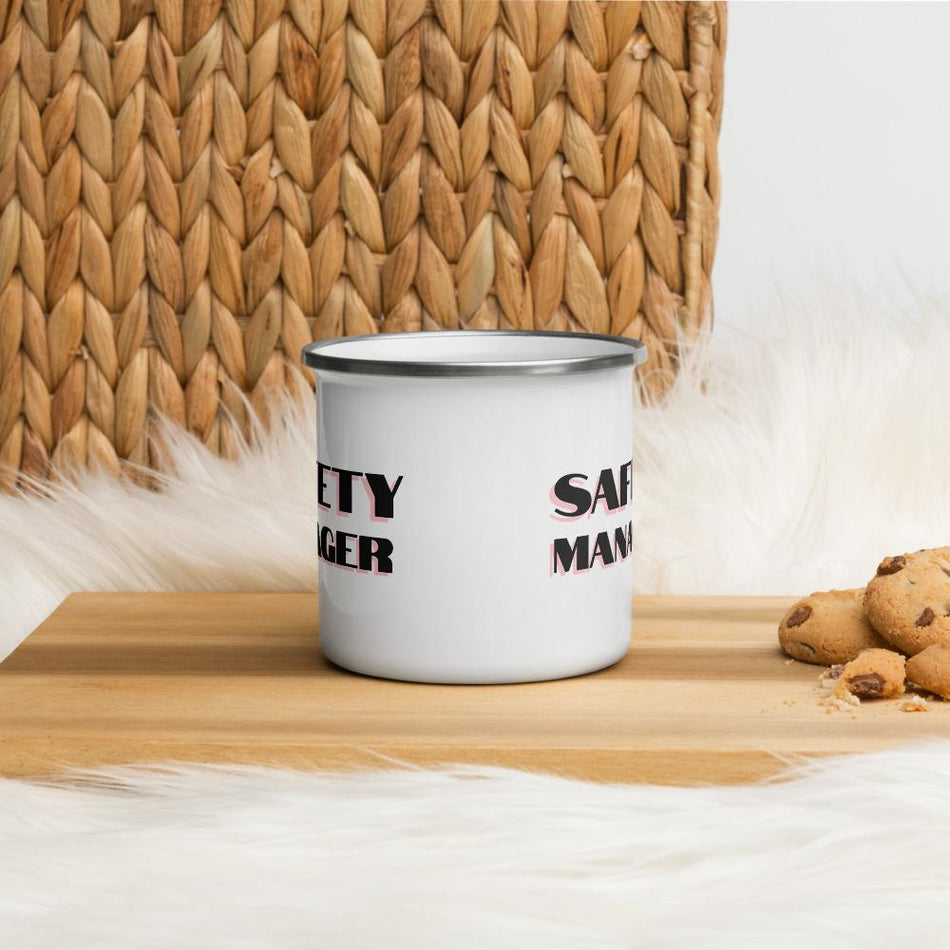 White metal mug with a silver rim with "Safety Manager" in bold text with a pink drop shadow across the side.