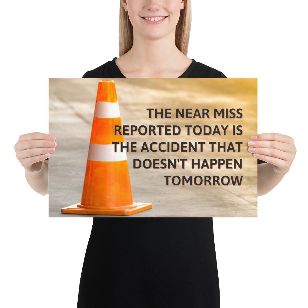 A workplace safety poster showing an orange safety cone with the slogan the near miss reported today is the accident that doesn't happen tomorrow.
