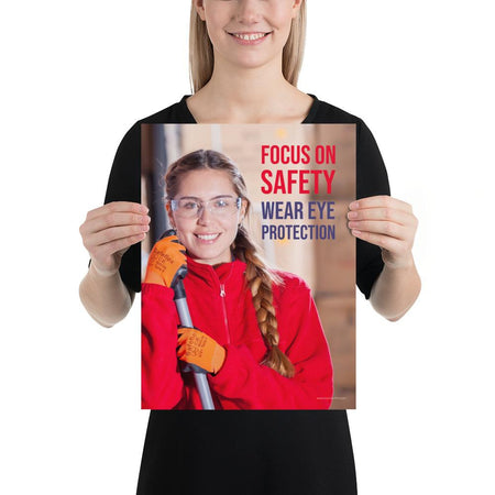 An eye safety poster of a young woman wearing safety glasses and orange gloves smiling as she works in a warehouse with a safety slogan in the top right corner.