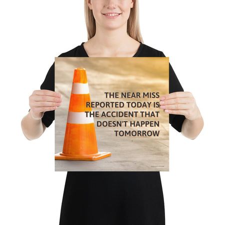 A workplace safety poster showing an orange safety cone with the slogan the near miss reported today is the accident that doesn't happen tomorrow.