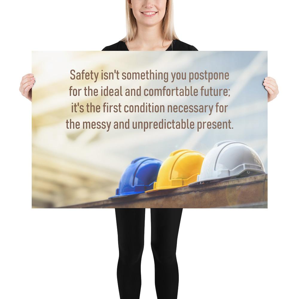 A workplace safety poster showing 3 multi colored hardhats sitting on a wall with the slogan safety isn't something you postpone for the ideal and comfortable future. It's the first condition necessary for the messy and unpredictable present.