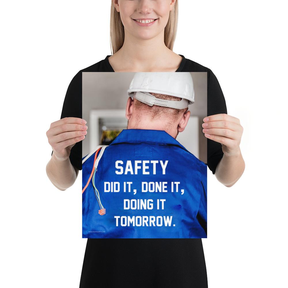 Safety poster showing an electrician wearing a hard hat and holding cables working on an electrical panel with text on the back of his bright blue shirt.