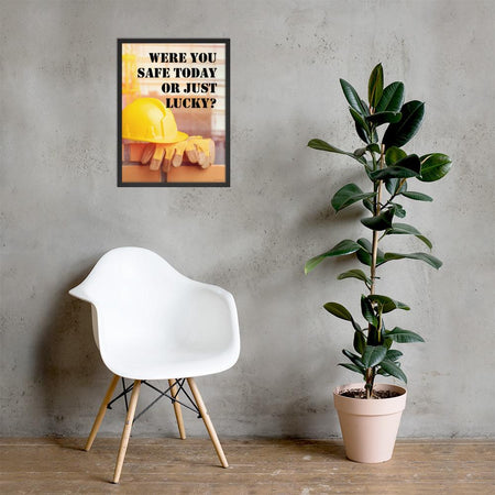 A workplace safety poster showing a yellow hard hat and some gloves sitting on a brick wall on a construction site with the slogan were you safe today, or just lucky written in black stencil font.