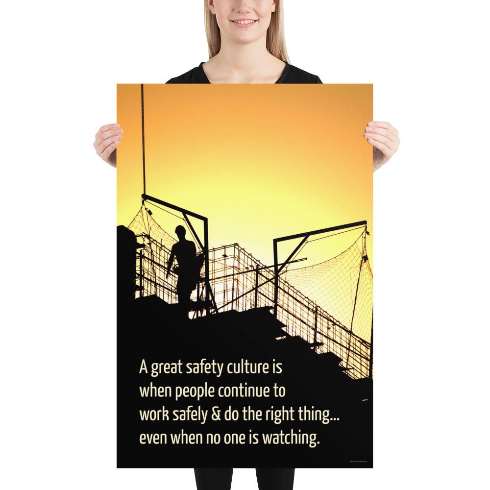 A construction safety poster showing the silhouette of a construction worker working on a building with a bright yellow sunset in the background and a safety slogan in the bottom left corner.