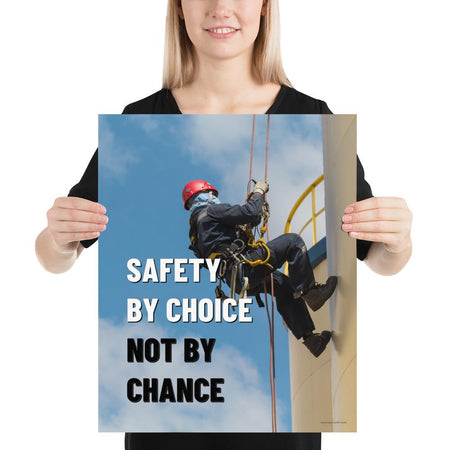 A fully harnessed man wearing a hard hat scaling the side of a building with a bright blue sky and clouds in the background with the text safety by choice, not by chance in bold text to his left.