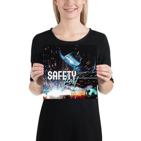 A safety poster showing a close-up of a welder welding a pipe while wearing a welding hood with bright sparks flying all around with the slogan safety first.