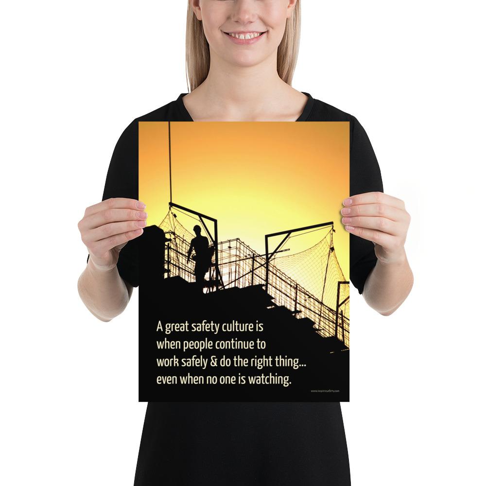 A construction safety poster showing the silhouette of a construction worker working on a building with a bright yellow sunset in the background and a safety slogan in the bottom left corner.