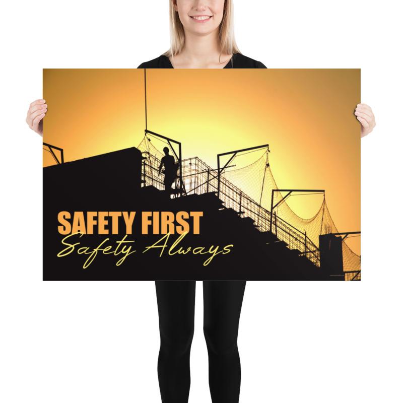 A workplace safety poster showing a construction site and construction workers being silhouetted by a bright and beautiful sunset of different shades of orange with the slogan safety first, safety always.