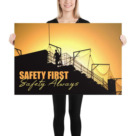 A workplace safety poster showing a construction site and construction workers being silhouetted by a bright and beautiful sunset of different shades of orange with the slogan safety first, safety always.