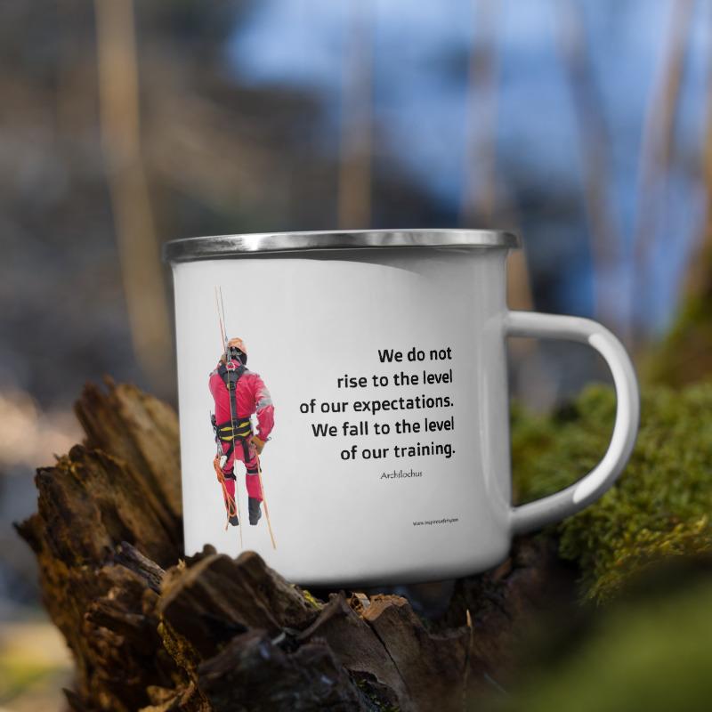 White metal mug with a silver rim with a quote by Archilochus that says "We do not rise to the level of our expectations. We fall to the level of our training." with a man in a safety harness to the side and the Inspire Safety logo on the other side.