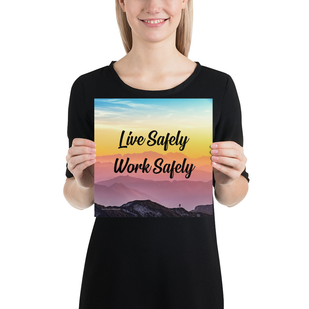 A safety poster showing a mountain range with a beautiful gradient in the sky of blue, yellow, and pink with the safety slogan "Live Safely Work Safely."