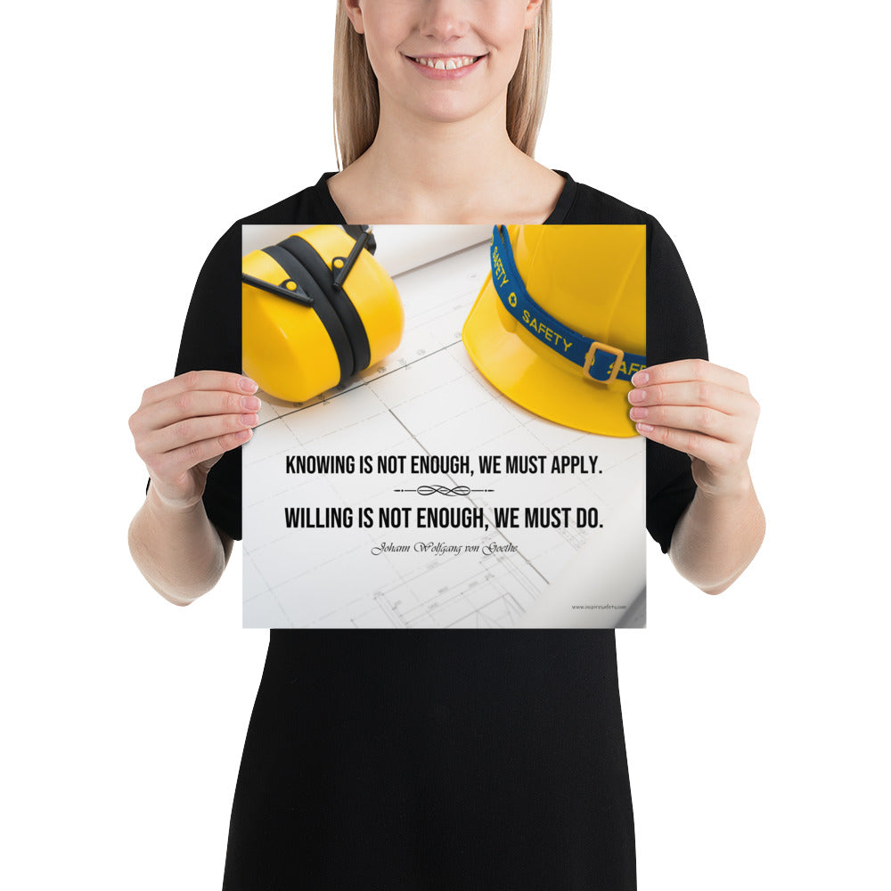A safety poster showing a yellow hard hat and yellow ear muffs on blueprints with a safety quote by Johann Wolfgang von Goethe that says "Knowing is not enough, we must apply. Willing is not enough, we must do."