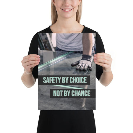 A workplace safety poster showing a close-up of a worker's hands grabbing panes of glass with gloves on with the slogan safety by choice not by chance.