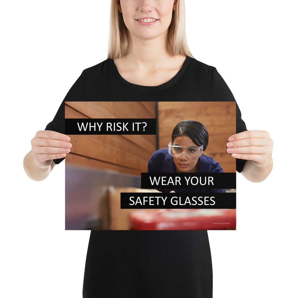 A safety poster showing a woman using a table saw to cut wood wearing safety glasses with the slogan "Why Risk It? Wear Your Safety Glasses."