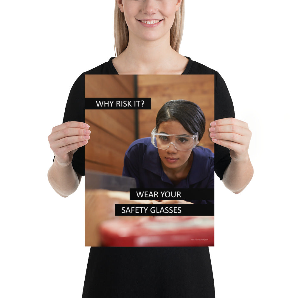 A safety poster showing a woman using a table saw to cut wood wearing safety glasses with the slogan "Why Risk It? Wear Your Safety Glasses."