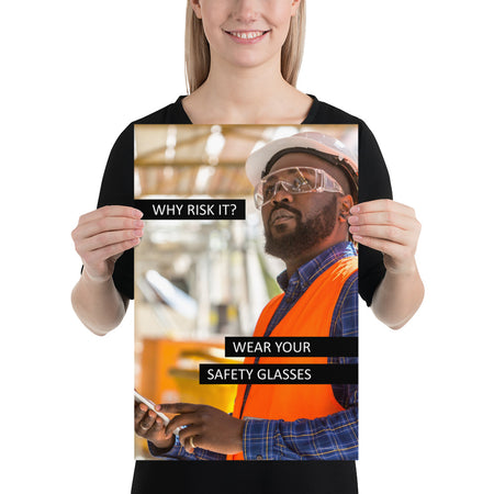 A safety poster showing a man in a reflective vest, hard hat, and safety glasses working with the slogan "Why risk it? Wear your safety glasses."