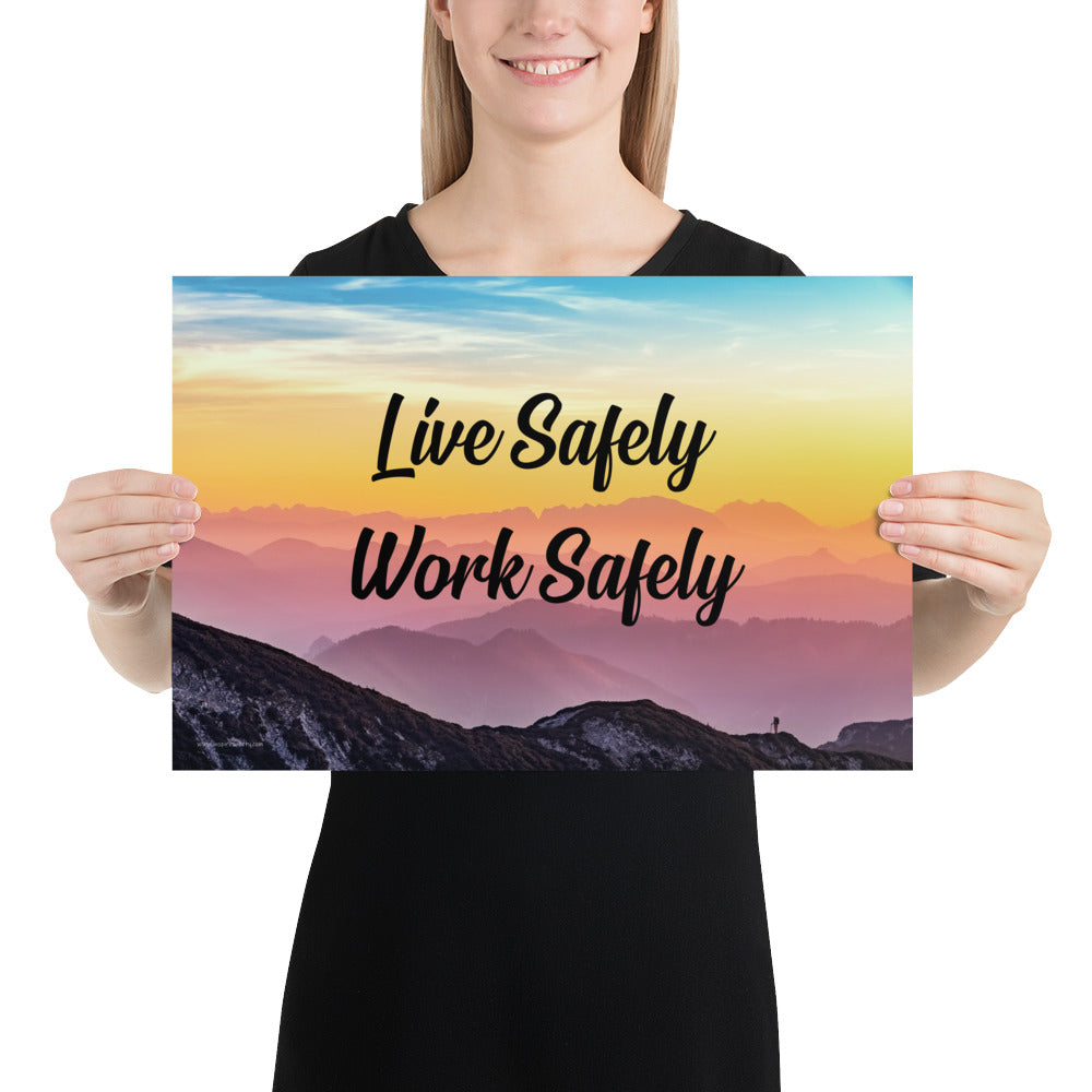 A safety poster showing a mountain range with a beautiful gradient in the sky of blue, yellow, and pink with the safety slogan "Live Safely Work Safely."