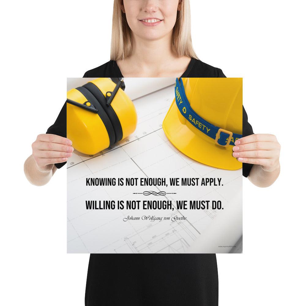 A safety poster showing a yellow hard hat and yellow ear muffs on blueprints with a safety quote by Johann Wolfgang von Goethe that says "Knowing is not enough, we must apply. Willing is not enough, we must do."