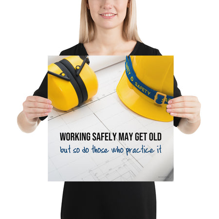 A construction safety poster showing yellow ear muffs and a hard hat resting on blueprints with the slogan "Working safely may get old, but so do those who practice it."