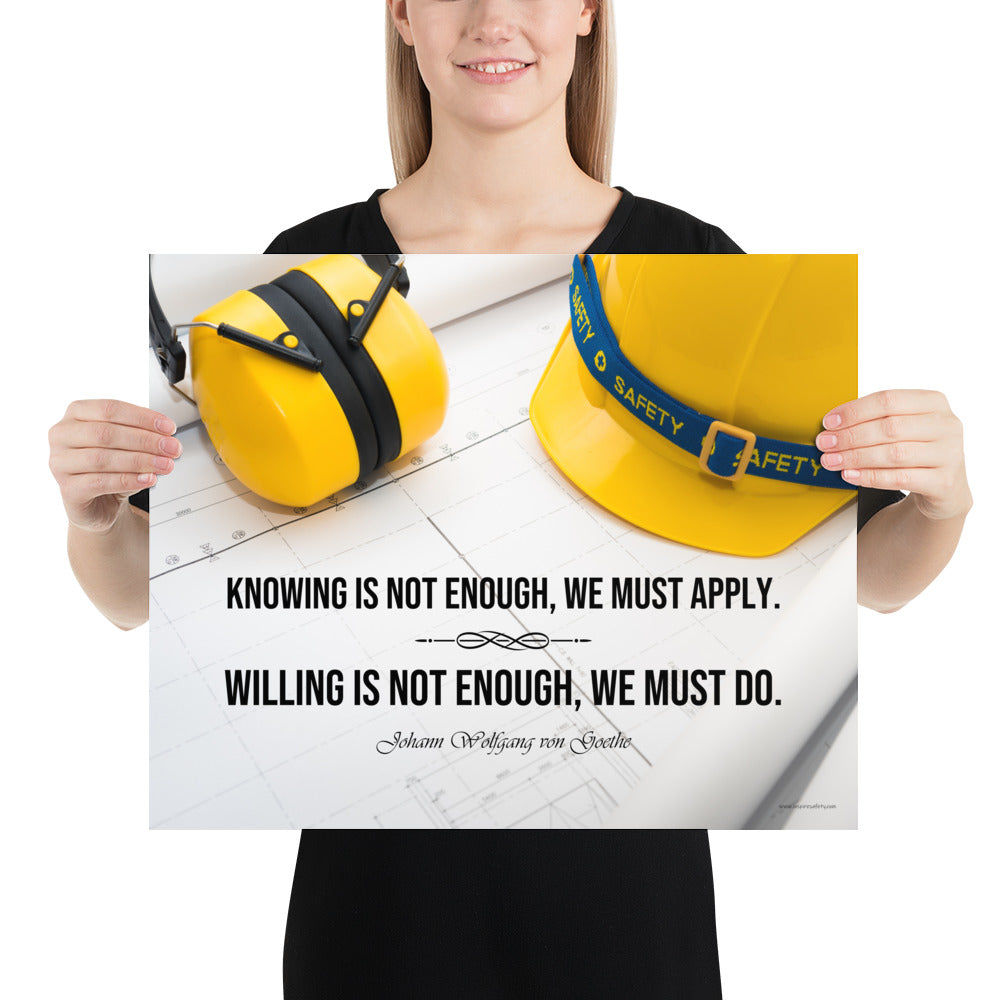 A safety poster showing a yellow hard hat and yellow ear muffs on blueprints with a safety quote by Johann Wolfgang von Goethe that says "Knowing is not enough, we must apply. Willing is not enough, we must do."