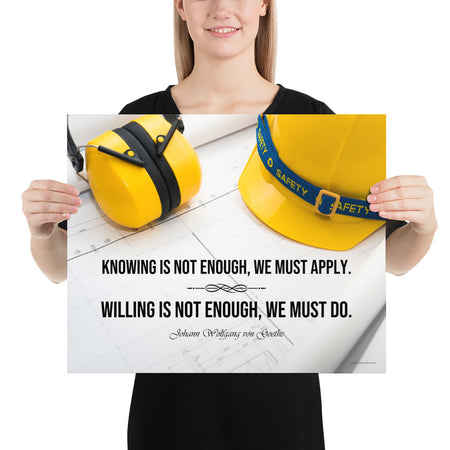 A safety poster showing a yellow hard hat and yellow ear muffs on blueprints with a safety quote by Johann Wolfgang von Goethe that says "Knowing is not enough, we must apply. Willing is not enough, we must do."