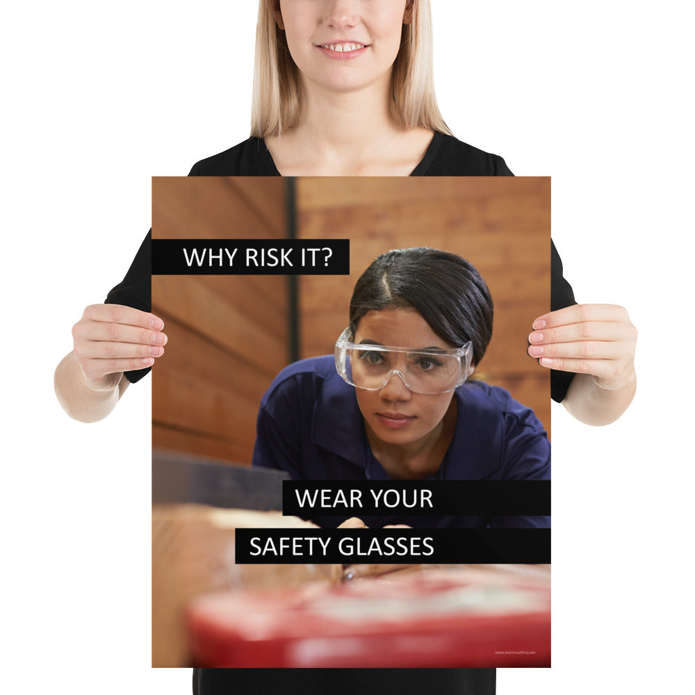 A safety poster showing a woman using a table saw to cut wood wearing safety glasses with the slogan "Why Risk It? Wear Your Safety Glasses."