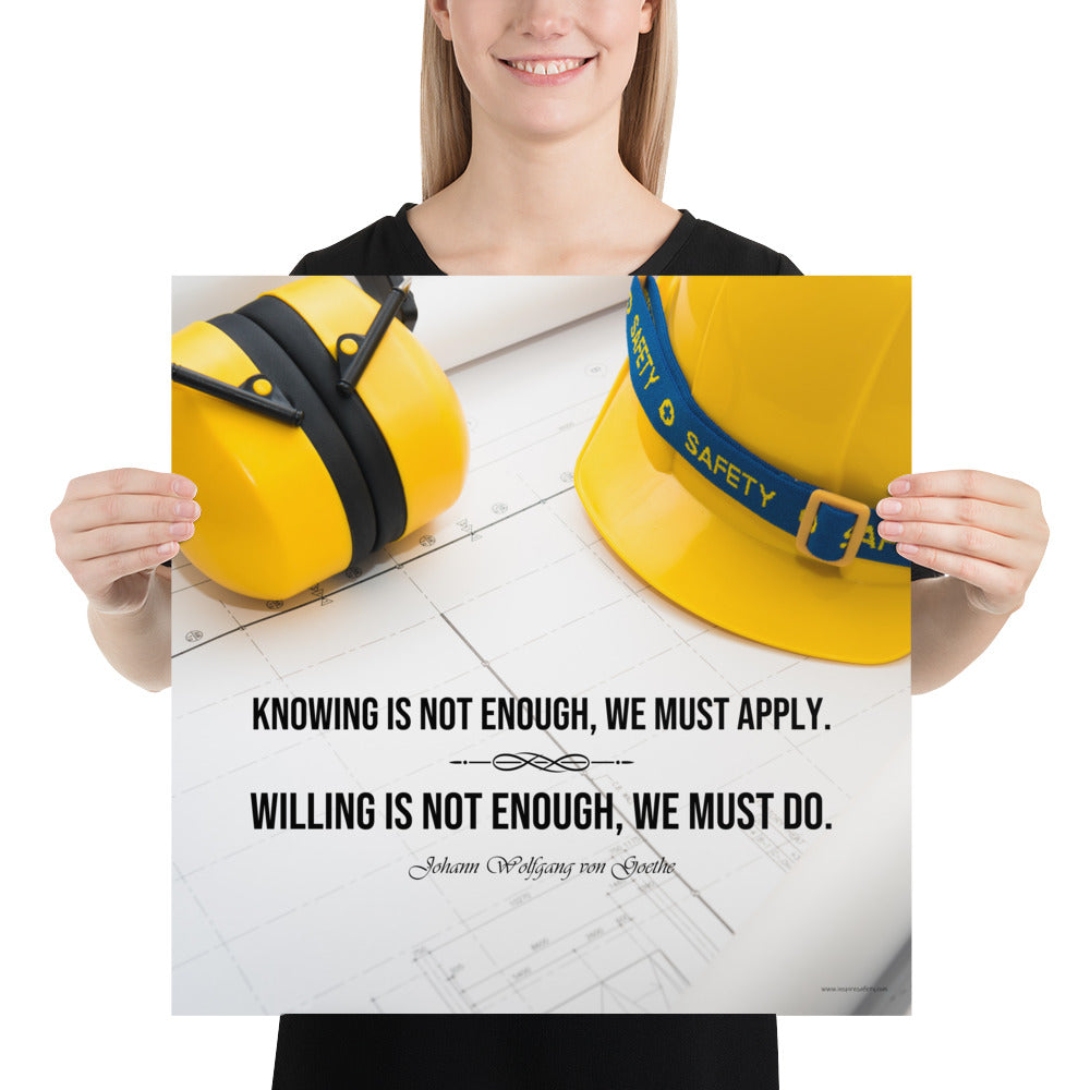 A safety poster showing a yellow hard hat and yellow ear muffs on blueprints with a safety quote by Johann Wolfgang von Goethe that says "Knowing is not enough, we must apply. Willing is not enough, we must do."