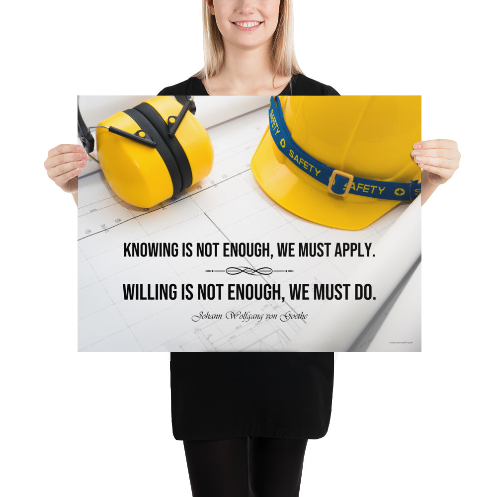 A safety poster showing a yellow hard hat and yellow ear muffs on blueprints with a safety quote by Johann Wolfgang von Goethe that says "Knowing is not enough, we must apply. Willing is not enough, we must do."