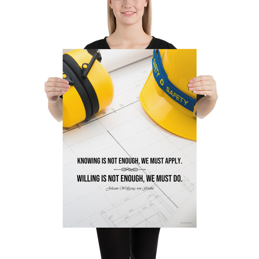 A safety poster showing a yellow hard hat and yellow ear muffs on blueprints with a safety quote by Johann Wolfgang von Goethe that says "Knowing is not enough, we must apply. Willing is not enough, we must do."