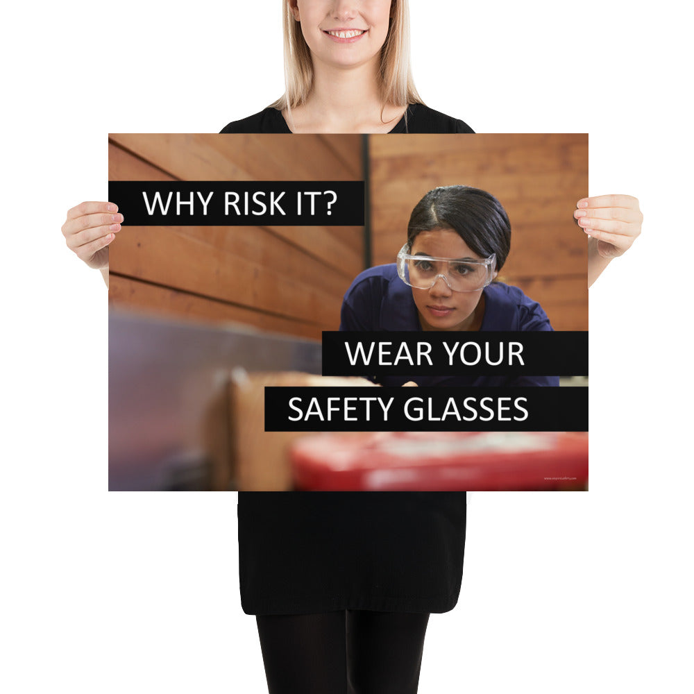 A safety poster showing a woman using a table saw to cut wood wearing safety glasses with the slogan "Why Risk It? Wear Your Safety Glasses."