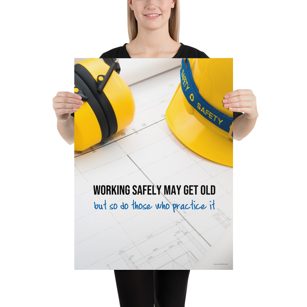 A construction safety poster showing yellow ear muffs and a hard hat resting on blueprints with the slogan "Working safely may get old, but so do those who practice it."